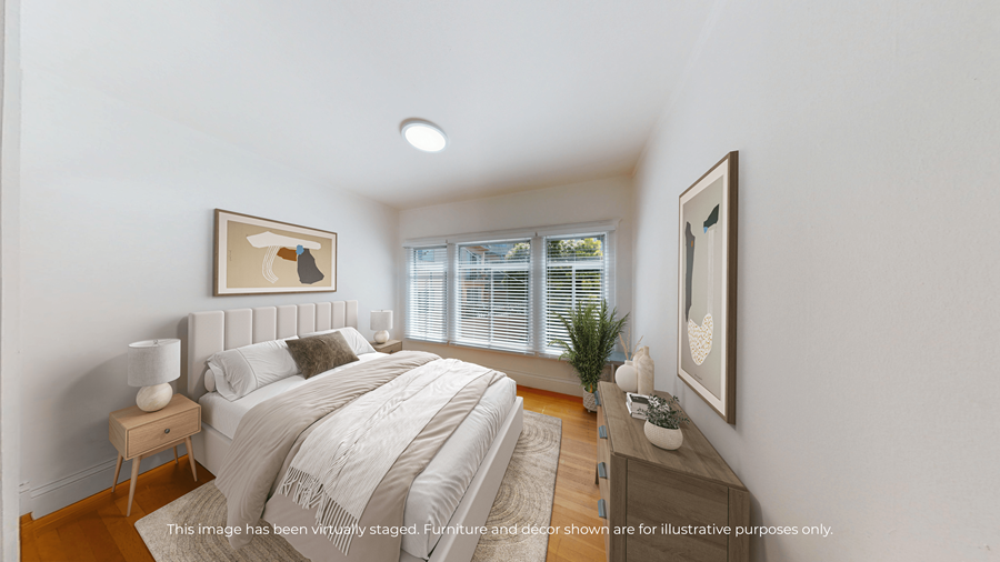A bedroom with a large bed and a window with blinds.